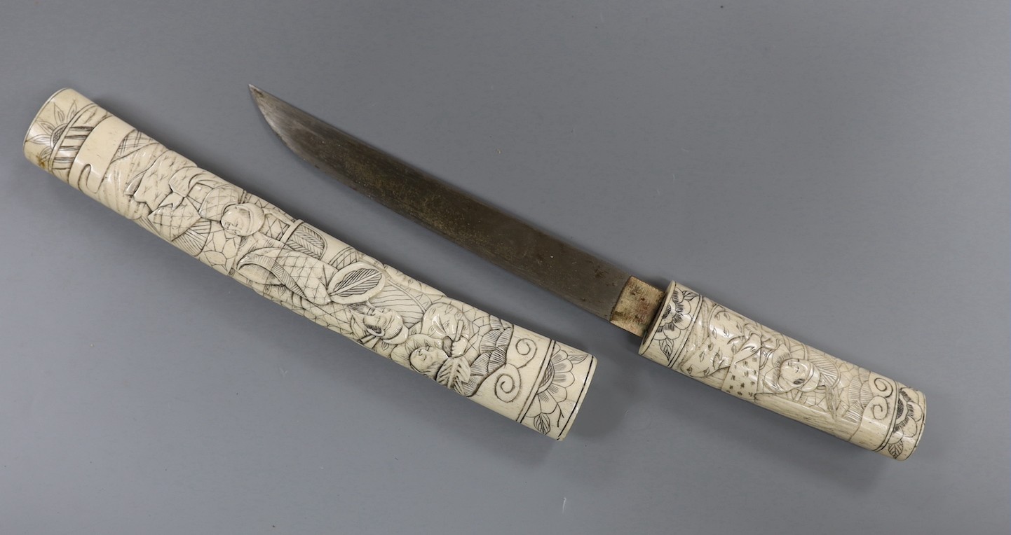 A Japanese carved bone tanto, c.1900, carved with numerous figures, overall 36cm